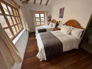 奥兰太坦波帕尔瓦旅馆的一间卧室设有两张床和两个窗户。