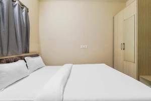 兰奇Super OYO Hotel Rameshwar的卧室配有白色的床和门