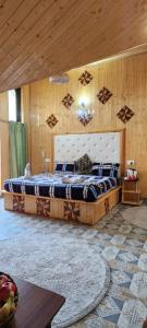 斯利那加Behtereen resort的一间卧室设有一张带木制天花板的大床