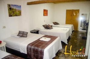 比利亚维哈Hostel Tatacoa的酒店客房,配有3张带白色床单的床