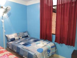 莫约班巴Depa - 204的一间卧室配有一张蓝色墙壁和红色窗帘的床