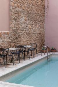 雅典雅典艺术套房酒店的一组桌子和椅子,位于游泳池旁