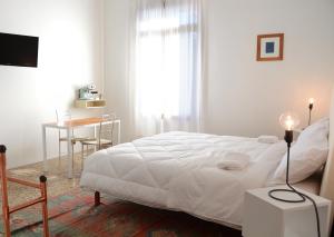 Rosà贾尔迪诺亚佩里住宿加早餐旅馆的白色卧室配有床、桌子和书桌