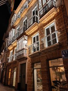加的斯VG - Villa de Andas suites的街道上带阳台的砖砌建筑