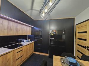 纳文丘夫Różana 4的厨房配有黑色橱柜和黑色冰箱。