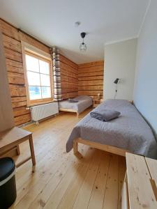 ZELTA KROGS的卧室设有木墙、一张床和窗户
