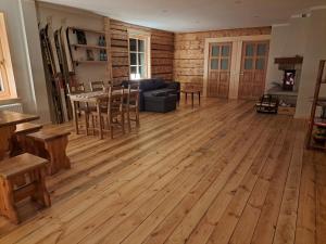 ZELTA KROGS的客厅铺有木地板,配有桌椅。
