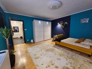 纳文丘夫Różana 4的一间卧室设有一张床和蓝色的墙壁