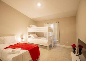 德通纳海滩海岸Beach Bliss - 5 MIN WALK to BEACH - Family Retreat的卧室配有带红色毯子的白色双层床