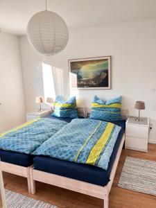 洛尔施Helle und gemütliche Ferienwohnung in Lorsch的一间卧室配有一张带蓝色棉被和枕头的床
