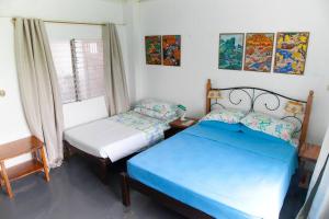 BuenavistaVilla Elena Guimaras的一间卧室设有两张床和窗户。