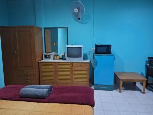 涛岛Phonsomboon Guesthouse的客房设有一张床、一张书桌和电视