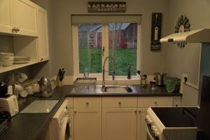 HemyockHot Tub Hideaway的厨房设有水槽和窗户。