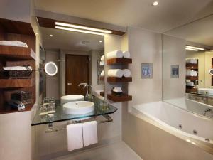 皇后镇皇后镇索菲特酒店及水疗中心的浴室配有盥洗盆和浴缸。