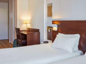 圣但尼巴黎圣但尼普莱耶尔阿德吉奥公寓式酒店的酒店客房配有一张床、一张书桌和一张书桌。