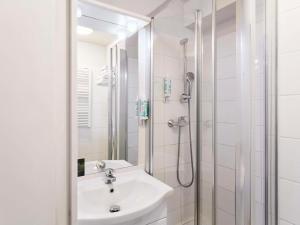 圣但尼巴黎圣但尼普莱耶尔阿德吉奥公寓式酒店的白色的浴室设有水槽和淋浴。