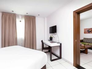 阿克拉阿克拉机场宜必思尚品酒店的一间卧室配有一张床和一张书桌及电视