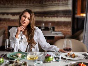 奥克兰索菲特奥克兰高架桥港酒店的坐在餐桌上吃一盘食物的女人