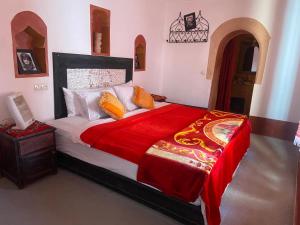 TamellaltTafsut dades guesthouse stay with locals的一间卧室配有一张带红色毯子的大床