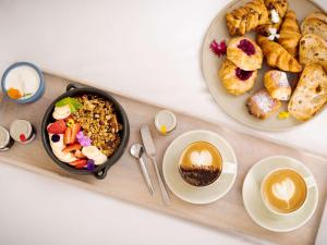 努萨角索菲特努萨太平洋度假酒店的一张桌子,上面放着一盘食物和一盘面包