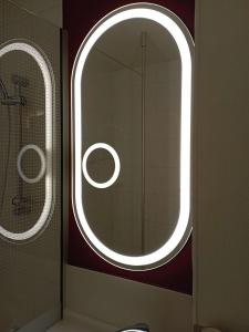 Fourmies里斯堂德莫尼宜必思酒店的一间带圆形镜子和窗户的浴室