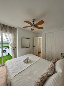 格兰阿利坎特Sonido del Mar的一间卧室配有一张带吊扇的床