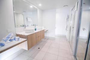 埃尔利海滩Club Wyndham Airlie Beach的白色的浴室设有2个盥洗盆和淋浴。