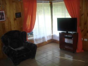 卡布尔瓜Cabañas Pichares的客厅配有椅子和电视
