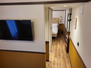 博讷Best Western Plus Au Grand Saint Jean的酒店客房的墙上配有平面电视