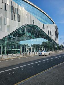 伦敦Tottenham Hotspurs Stays at the Gascoigne Suite的一辆汽车在玻璃建筑前行驶