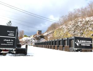 小樽RJ HOTELS OTARU的一辆火车停在雪覆盖的山丘旁边