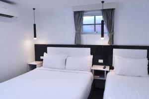 穆拉宾最佳西方白金汉国际酒店的配有2张床的带白色床单和枕头的客房