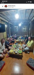 枚州县Mai Chau Home Holiday的一群人坐在桌子旁吃着食物