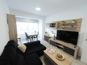 塔拉戈纳Apartamento New Tarraco的客厅配有黑色沙发和桌子