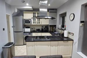 The HydeCozy & Elegant 4 Bedroom Home Near Wembley的厨房配有水槽和炉灶 顶部烤箱