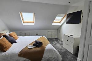 The HydeCozy & Elegant 4 Bedroom Home Near Wembley的一间卧室设有一张大床和两个窗户。