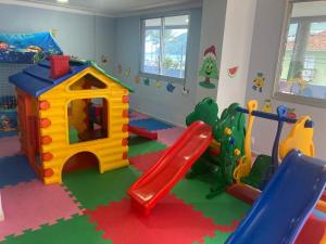 伯迪亚哥Apto em Bertioga , pé na areia的一个带滑梯和游乐场的儿童游戏室