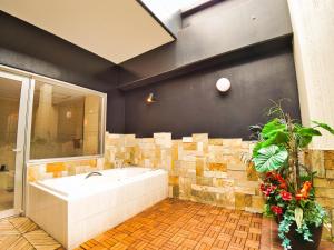 武雄市SKY Lmine Takeo LOVEHOTEL的带浴缸和瓷砖墙的浴室
