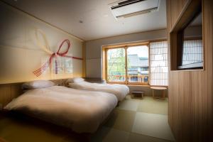 KinosakiSumihei Bettei Toki Toki的墙上有蝴蝶的房间,有三张床