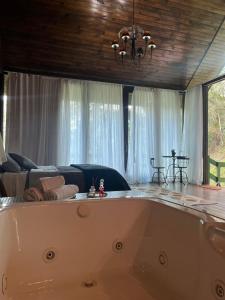 卢米亚Recanto dos Sonhos Guest House的客厅设有浴缸,配有沙发