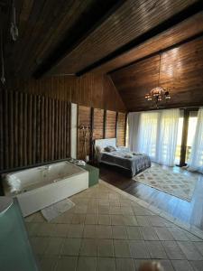 卢米亚Recanto dos Sonhos Guest House的带浴缸和床的大型浴室