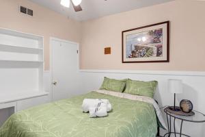 圣安东尼奥3b1b with private backyard的一间卧室配有一张带枕头的绿色床