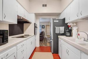 圣安东尼奥3b1b with private backyard的厨房配有白色橱柜和黑色冰箱。