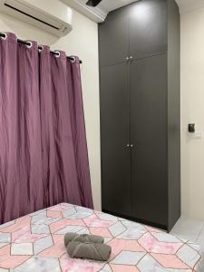 Bandar Puncak AlamRosevilla Homestay - 3R2B Fully Aircond WiFi的一间卧室配有一张床和一个紫色橱柜