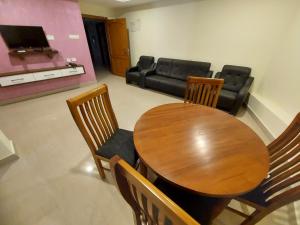 古鲁瓦尤尔Hotel Sree Gokulam Apartments的一间带桌椅和沙发的用餐室
