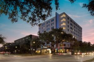 新奥尔良Hotel Tonnelle New Orleans, a Tribute Portfolio Hotel的一条高大的白色建筑,在街道前有棵树