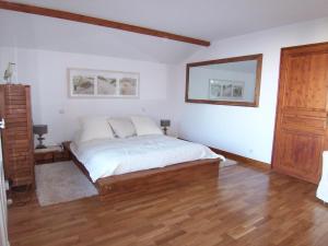阿卡雄Villa Arcachon, 6 pièces, 10 personnes - FR-1-374-12的一间卧室配有一张铺有木地板的白色床单。