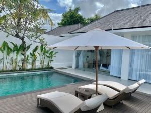 塞米亚克Alami Luxury Villa的游泳池旁的遮阳伞和椅子