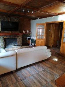 蓬塔阿雷纳斯Alojamiento Punta Arenas的客厅配有白色沙发和壁炉
