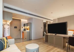 重庆重庆南岸希尔顿惠庭酒店的客厅配有大屏幕平面电视